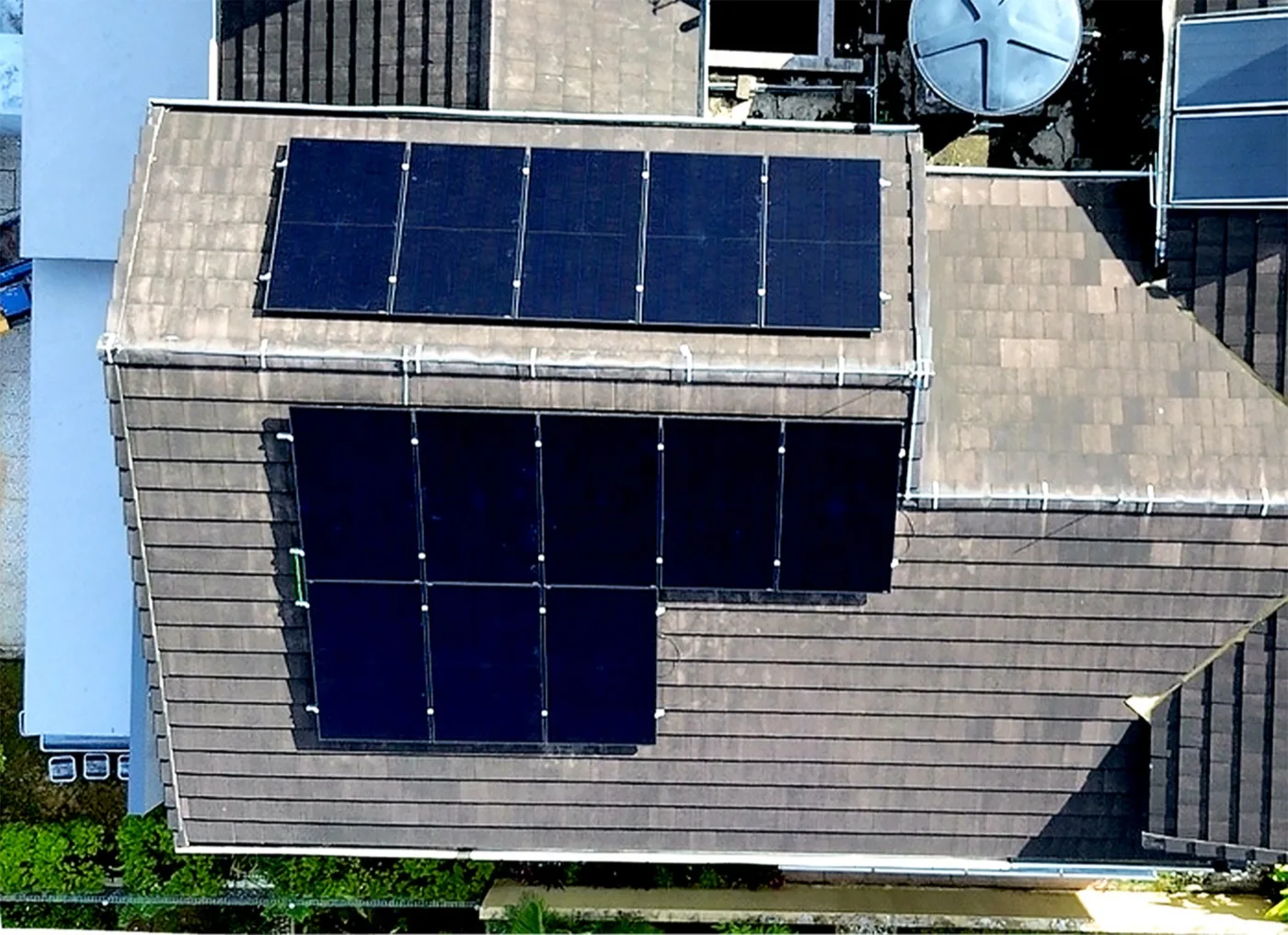 Thirteen solar panels across two roof faces, seen from above