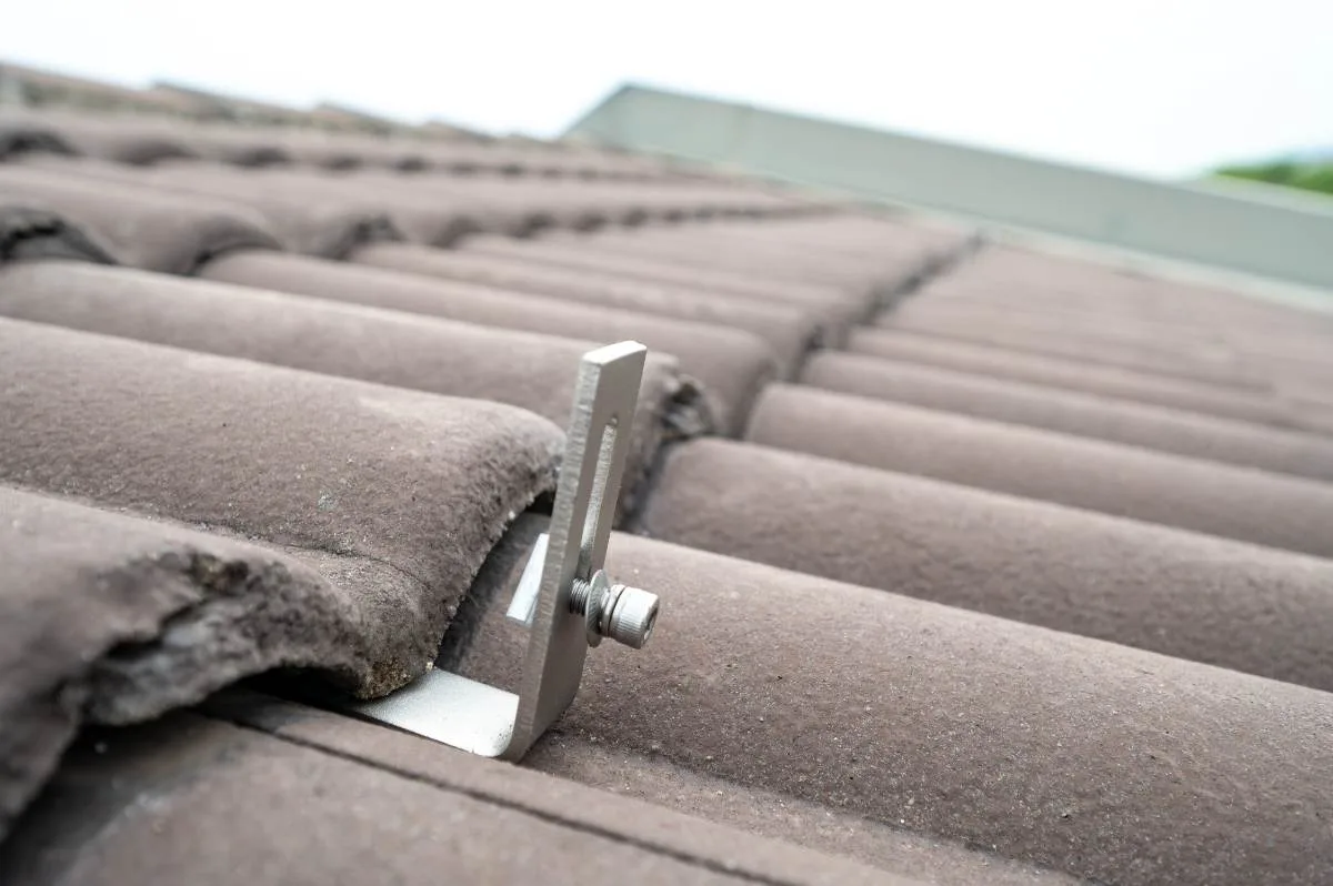 Roof mounting bracket fixed under a clay roof tile